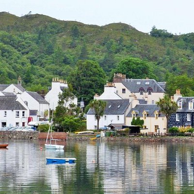 a small boat in a body of water with a mountain in the background