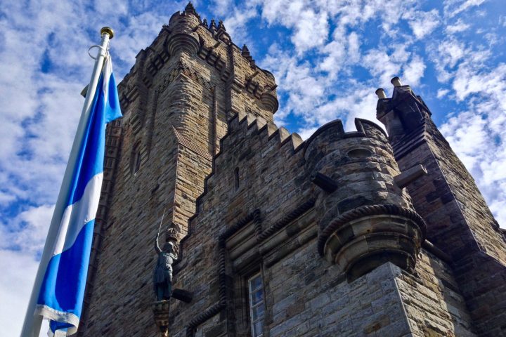 a large tall tower with a clock on the side of a building