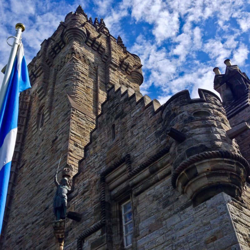 a large tall tower with a clock on the side of a building