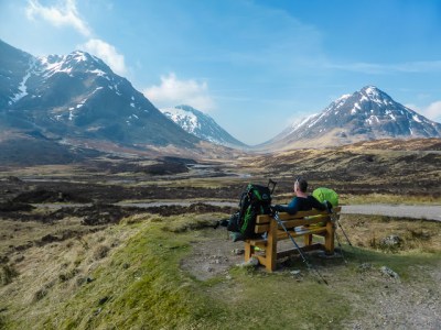 a man sitting on a bench in front of a mountain