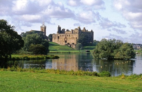 a castle on top of a lush green field with Ripley Castle in the background