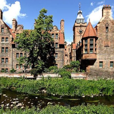 a castle with a clock tower in front of a house