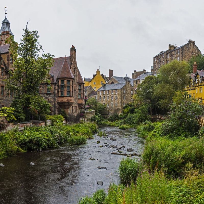 a castle with a clock on the side of a river