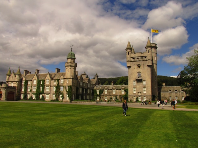 Castillo de Balmoral_ El refugio escocés de la reina Isabel II a castle with a clock tower on a cloudy day with Balmoral Castle in the background