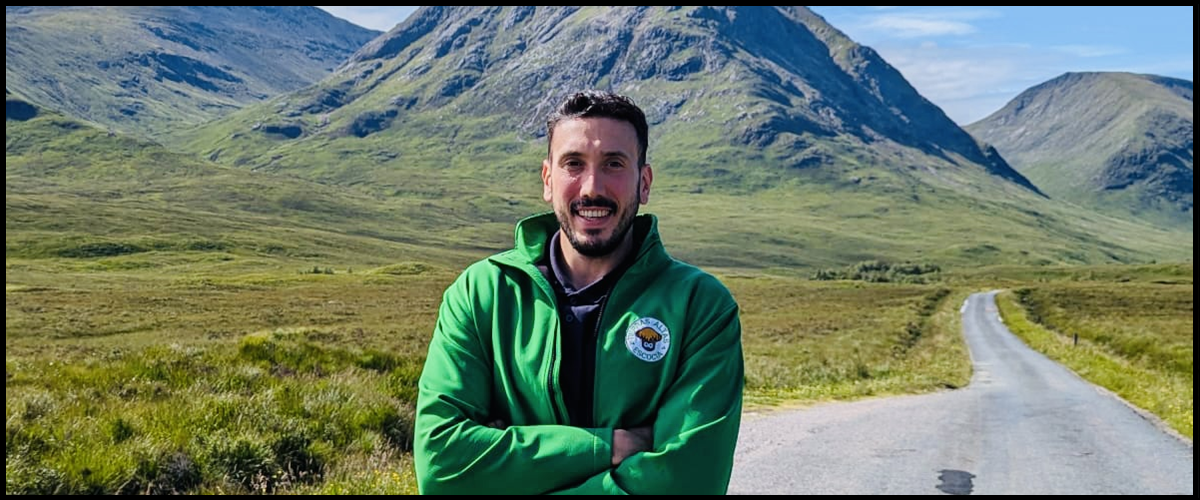 Adry, guía en Tierras Altas Escocia Tour Guide in a green field with a mountain in the background