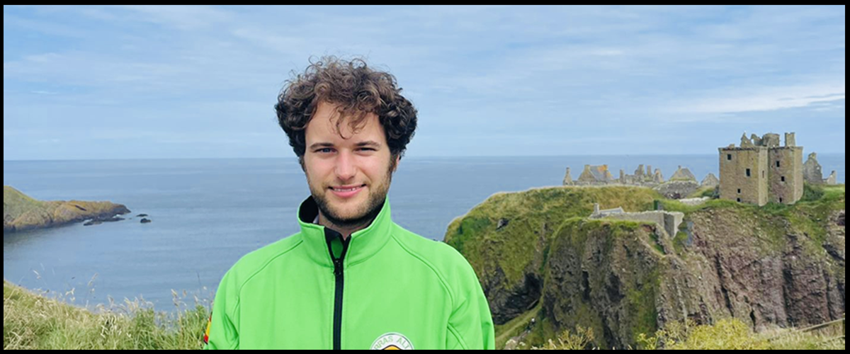 Guía Tierras Altas Escocia a boy standing in front of a body of water