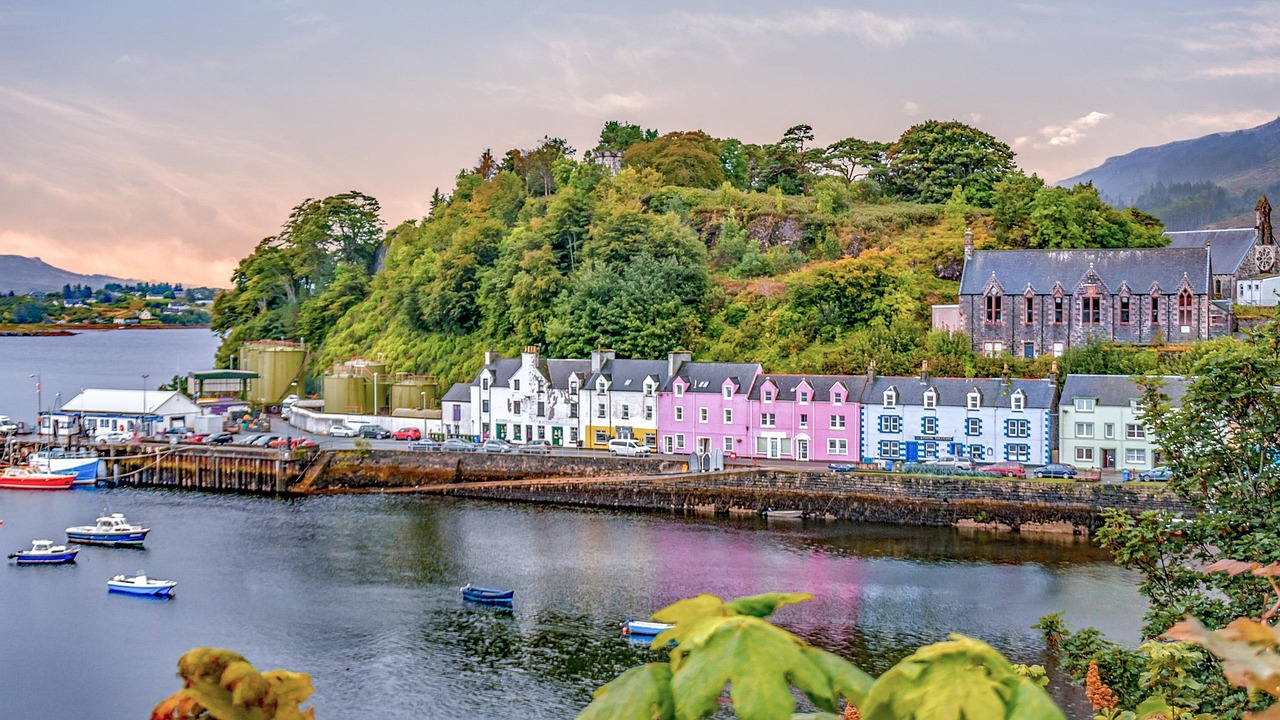 Portree_ Un destino imperdible en la Isla de Skye a boat floating along a river next to a body of water
