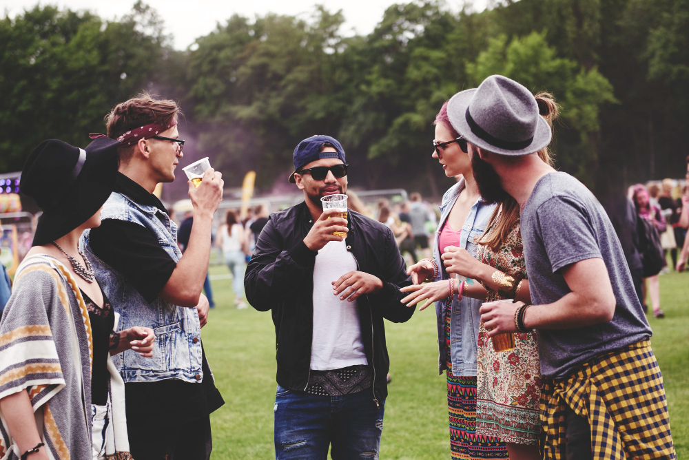 Los festivales de Edimburgo_ Una explosión de cultura y creatividad (1) Group of people chatting and drinking at an outdoor festival.