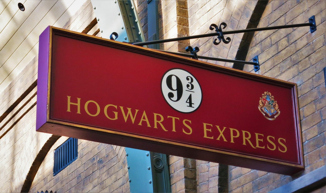 Sign for platform 9 3/4 and Hogwarts Express on brick wall.
