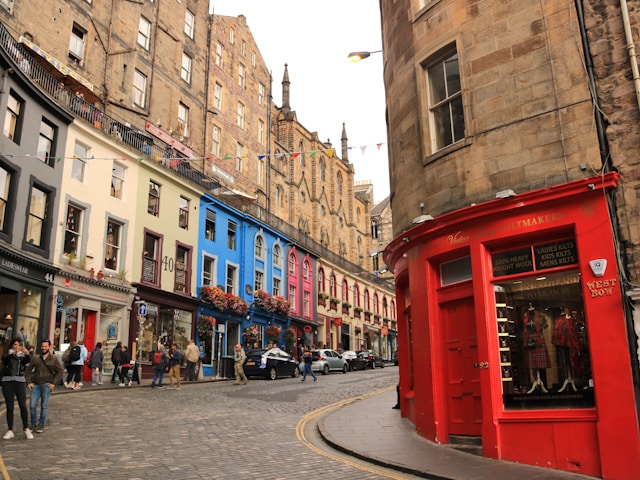 Curved street with colorful buildings and a red storefront in vibrant city setting.